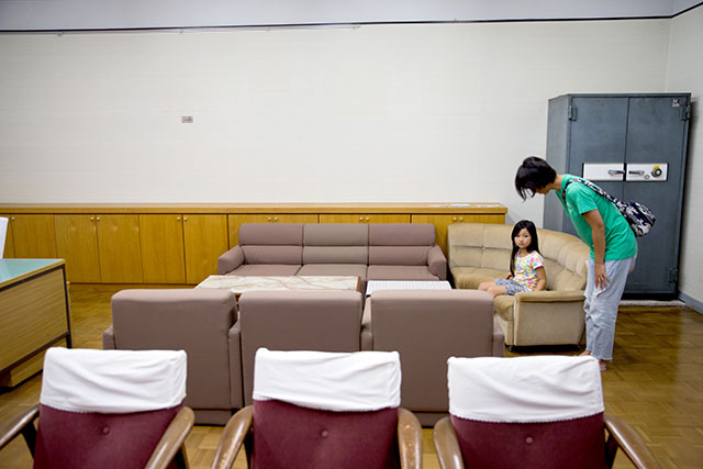 校長室でおじぎする母親
