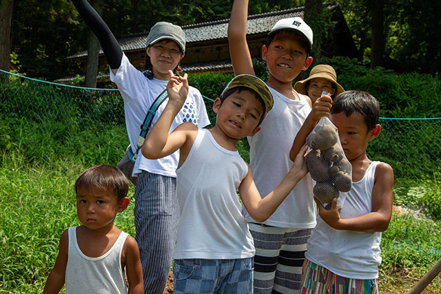 採れたおジャガを見せてくれている5人家族