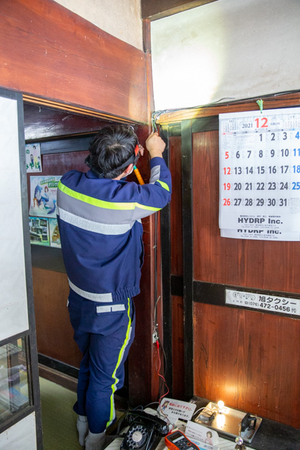 柱の電線を修理中