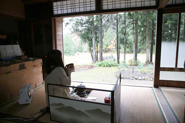 縁側のお茶席でお茶をのむ女性