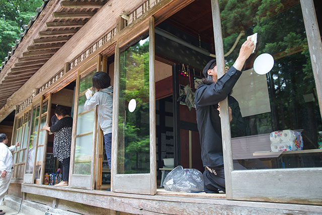 雨戸のガラスを磨いている人々