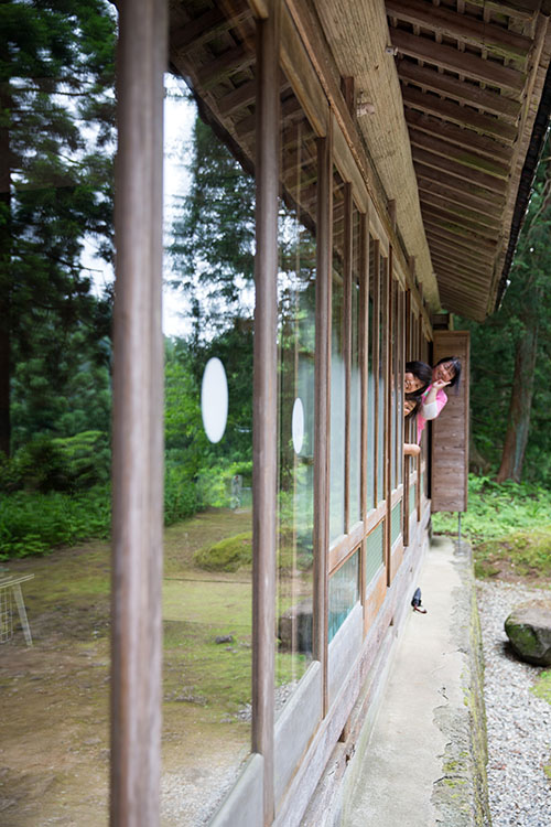 ぴかぴかに光る雨戸のガラスのむこうから顔を出す人