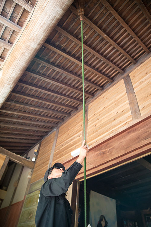 長ほうきを使って屋根裏側を蜘蛛の巣取り