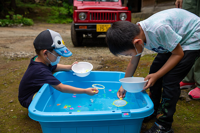 金魚すくいをする兄弟